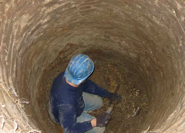 Pouring chemical fertilizer in the sewage well